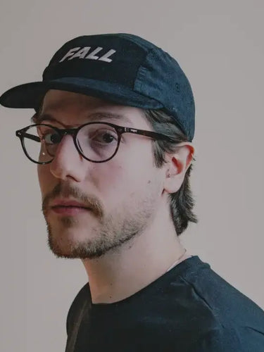 Homem usando bone preto com logo fall