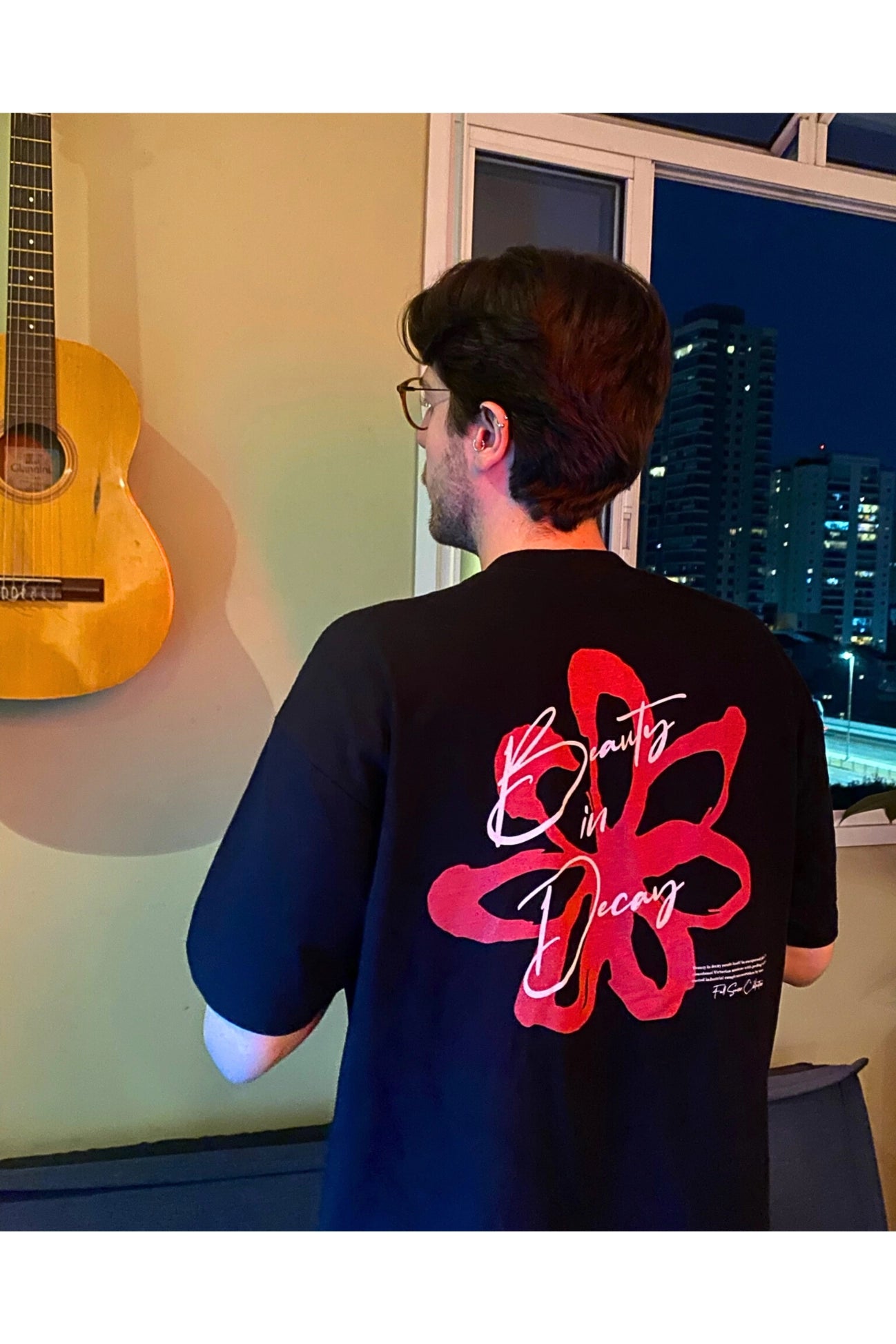 Outfit urbano homem usando camiseta oversized preta com caimento largo ombros caídos tendência street