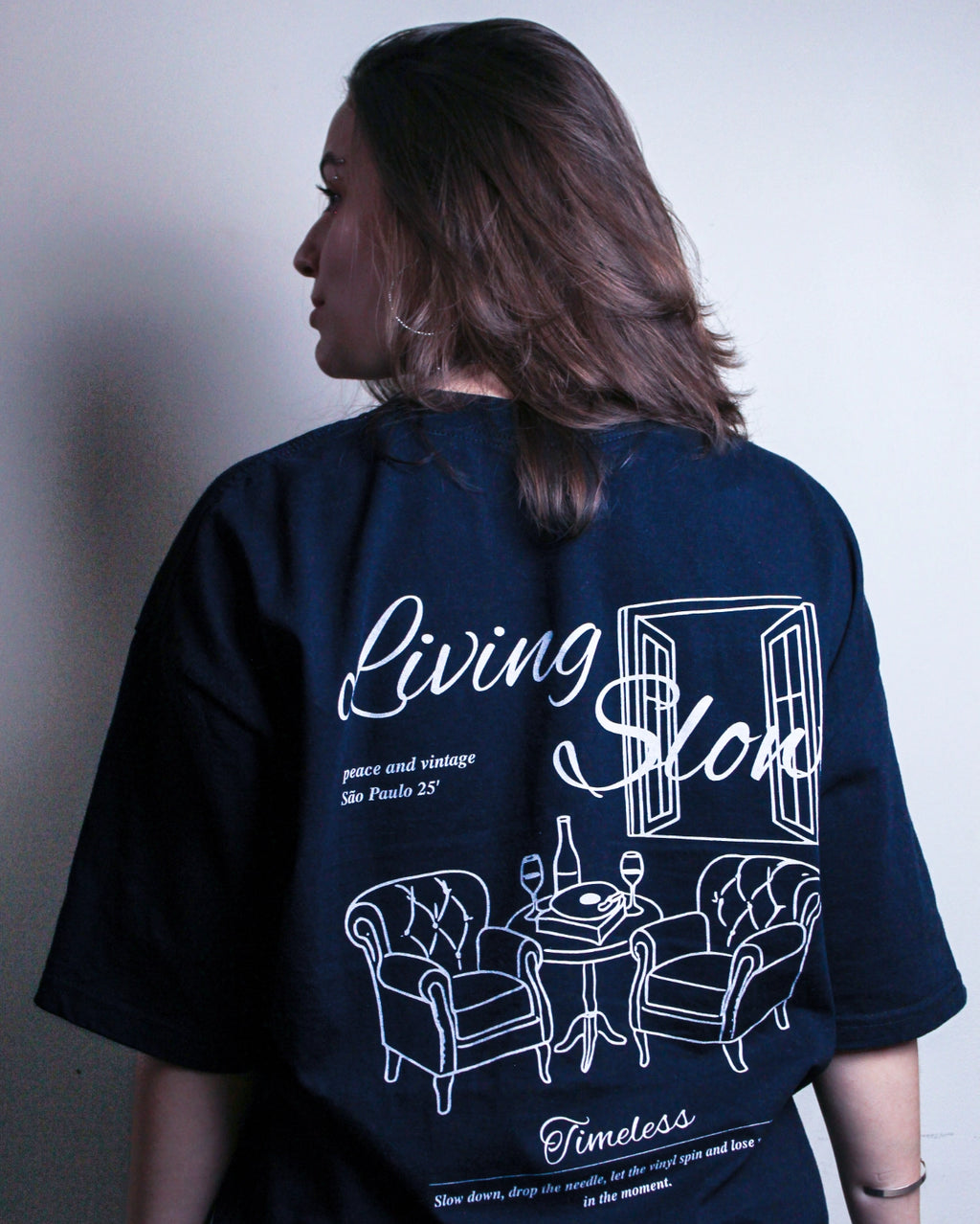 Visual costas camiseta preta estampada modelagem ampla ombros caídos